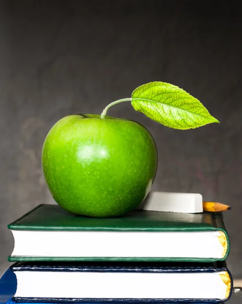 Apple, chalk and pencil on textbooks — Stock Photo, Image