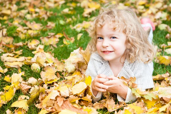 Niño acostado sobre hojas amarillas — Foto de Stock