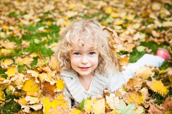 Niño acostado en hojas de otoño — Foto de Stock