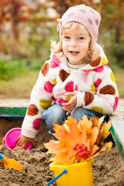 Ребенок на детской площадке осенью — стоковое фото