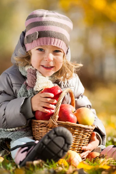 Kind mit Korb voller Äpfel — Stockfoto