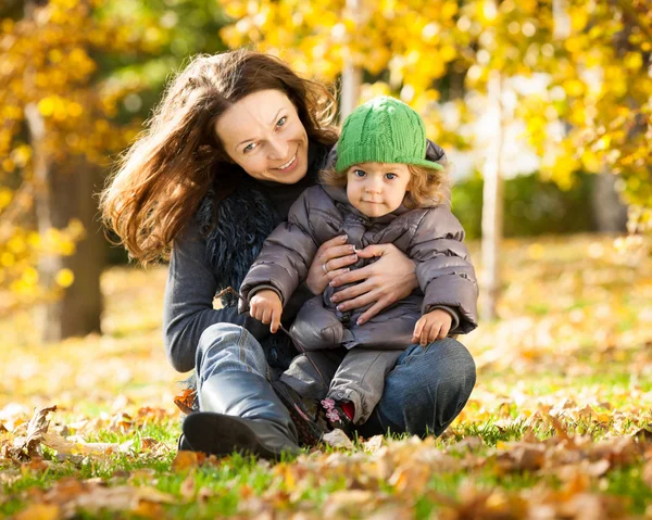 Donna con bambino si diverte in autunno — Foto Stock