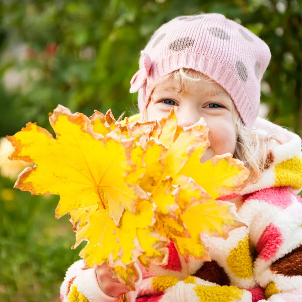 Kind hinter gelben Blättern versteckt — Stockfoto
