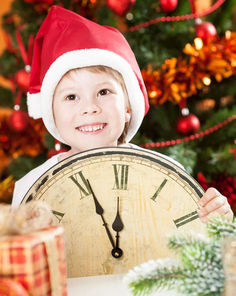 Kid no chapéu do Papai Noel segurando relógio vintage — Fotografia de Stock