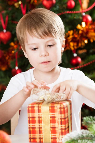 Junge öffnet Weihnachtsgeschenk — Stockfoto