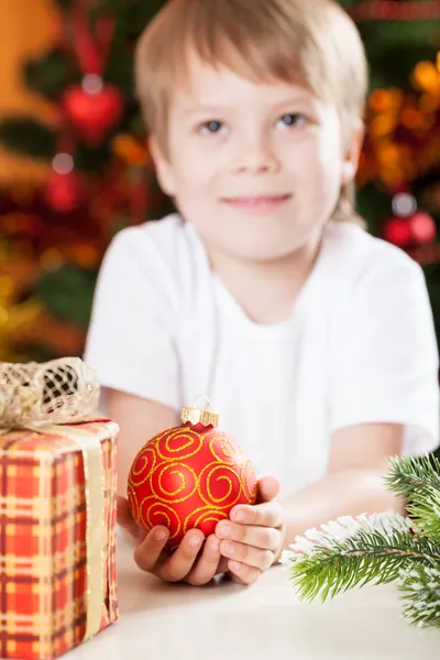 Sonriente niño sosteniendo la bola de Navidad Imagen De Stock