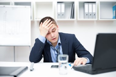 Thoughtful or stressful businessman at work clipart