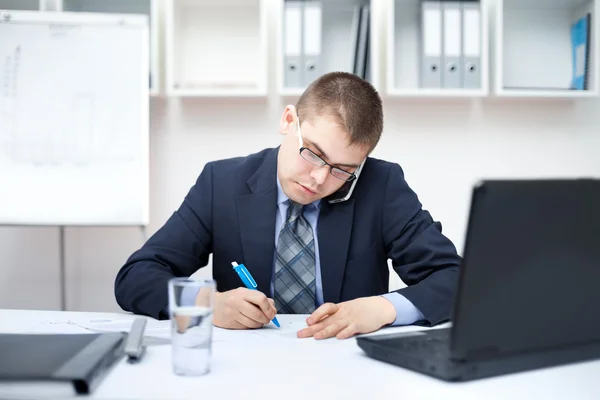 Porträt eines jungen Geschäftsmannes im Büro, der Papierkram erledigt — Stockfoto