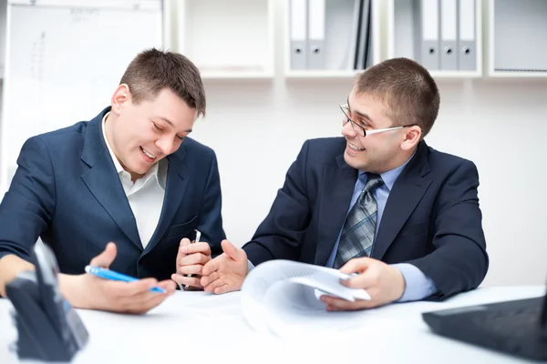 Dois jovens empresários rindo trabalhando juntos no escritório — Fotografia de Stock