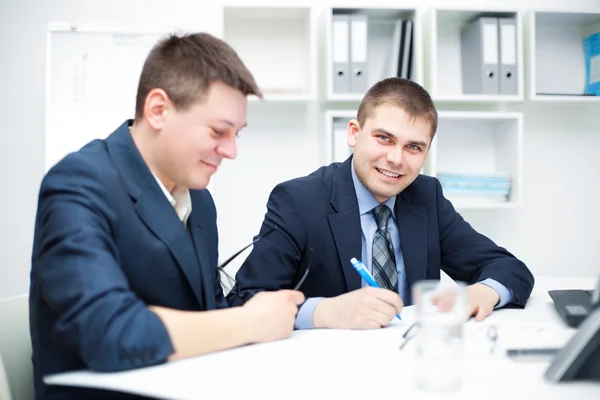 Ofiste birlikte çalışan iki mutlu genç iş adamı — Stok fotoğraf