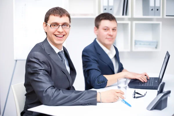 Två glada unga affärsmän som arbetar tillsammans på kontoret — Stockfoto