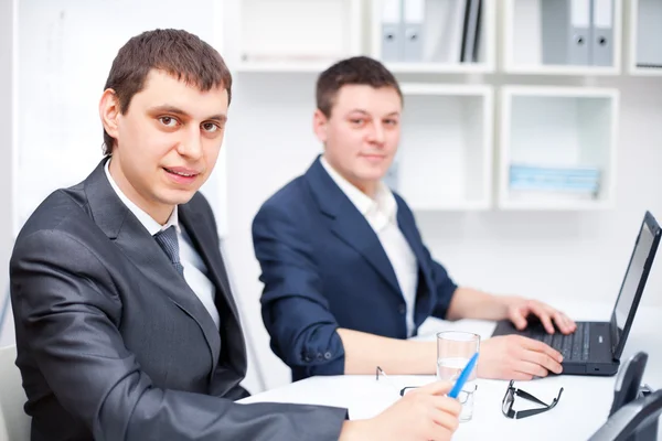 Dois jovens empresários que trabalham em conjunto no escritório — Fotografia de Stock