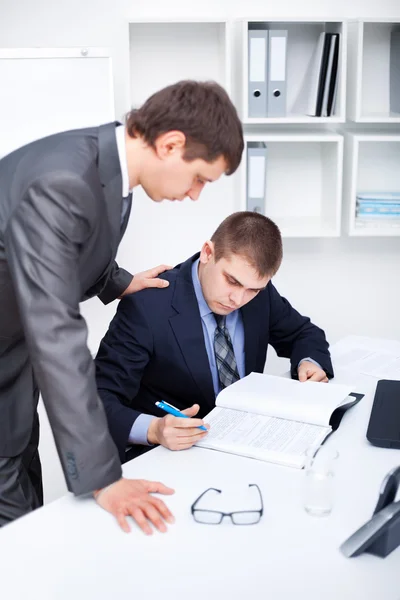 Dois jovens empresários que assinam papéis no escritório — Fotografia de Stock