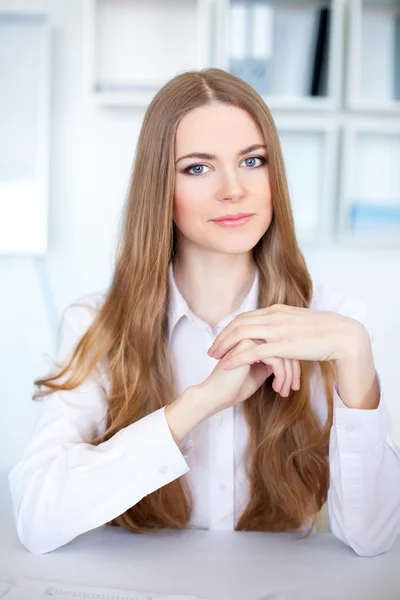 Retrato de una hermosa joven mujer de negocios sentada en el escritorio en br —  Fotos de Stock