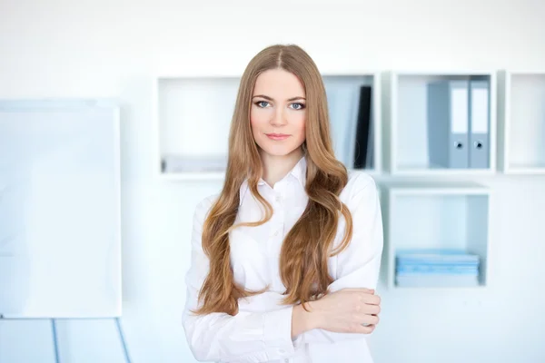 Retrato de jovem mulher de negócios feliz em pé no escritório — Fotografia de Stock