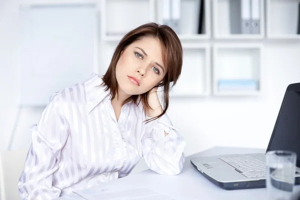 Müde junge Geschäftsfrau im hellen Büro — Stockfoto