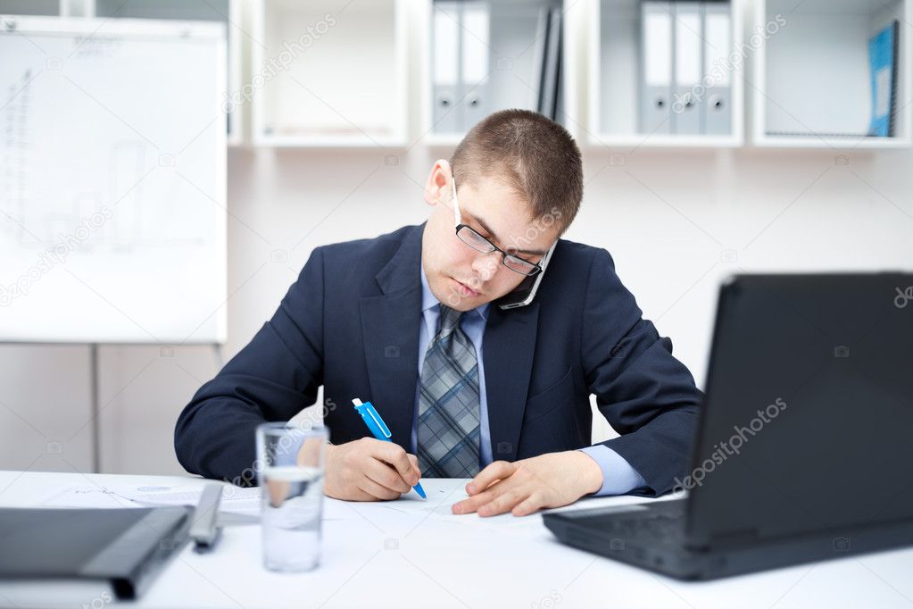Portrait of young business man in the office doing some paperwor