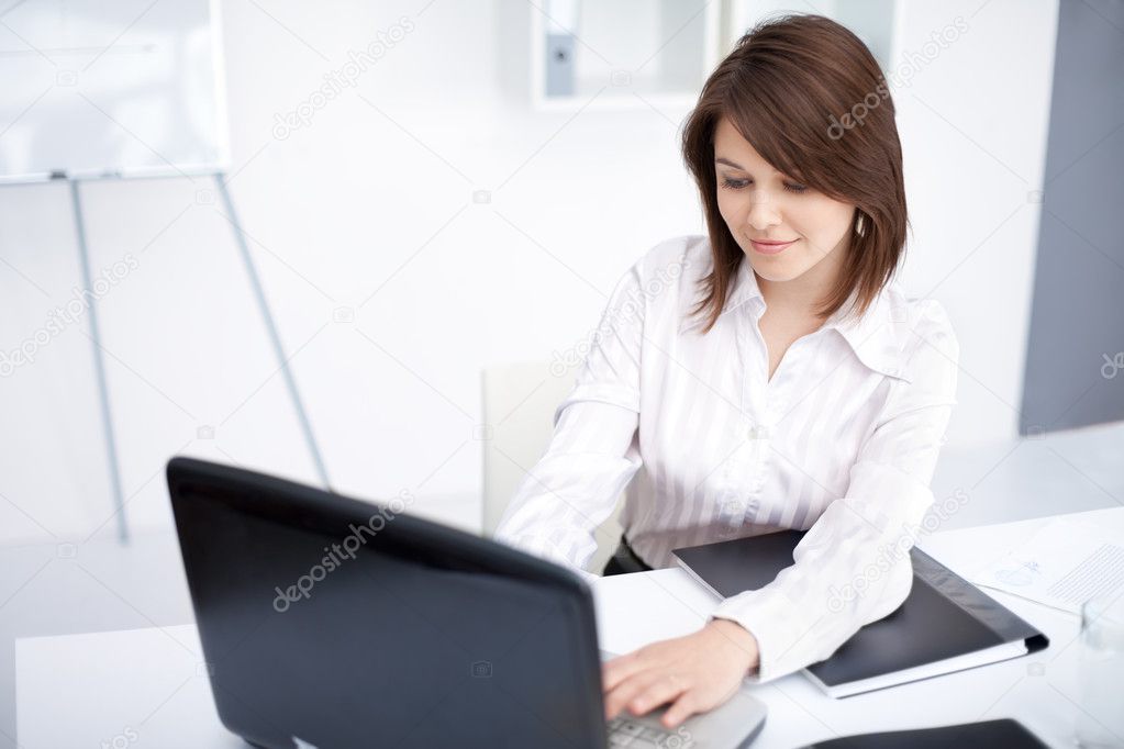 Portrait of beautiful young smiling business woman working on a