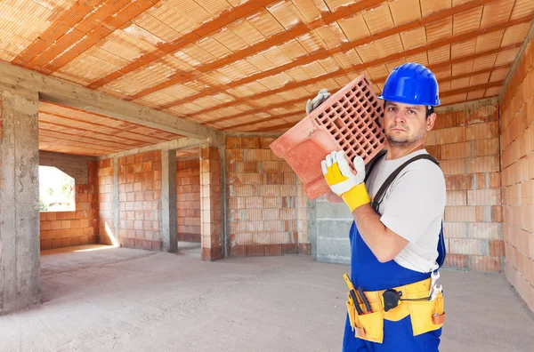 Arbeiter tragen Ziegel auf Baustelle — Stockfoto