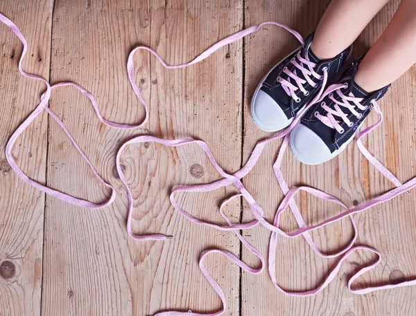 El problema - los pies infantiles y los cordones largos retorcidos de zapatos — Foto de Stock