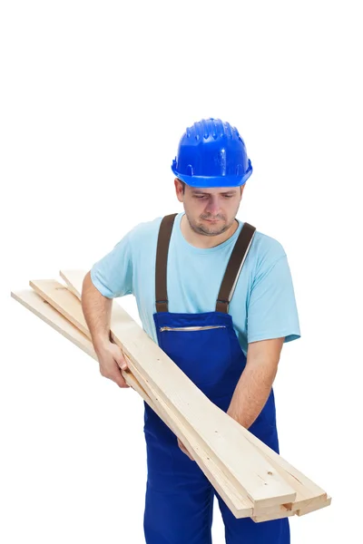 Trabalhador em uniforme transportando pranchas de madeira — Fotografia de Stock