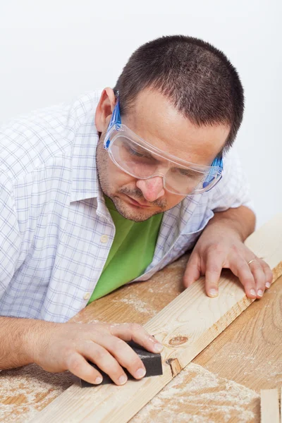 Man, oppoetsen houten planck — Stockfoto