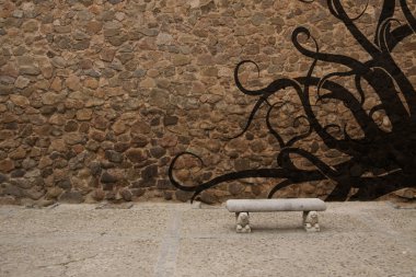 Old stone wall with bench and graffiti clipart