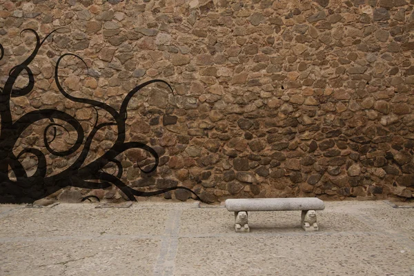 stock image Old stone wall with bench and graffiti