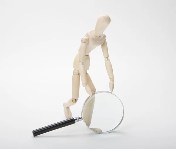 Wooden man with magnifying glass — Stock Photo, Image