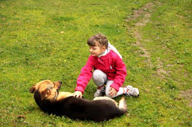 Kız köpekle oynuyor.