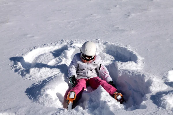 Mädchen liegt auf Schnee. Schnee-Engel — Stockfoto