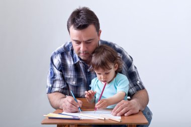 Toddler boy drawing with his father clipart