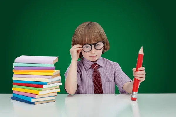 Мальчик-гений с книгами и большим карандашом — стоковое фото