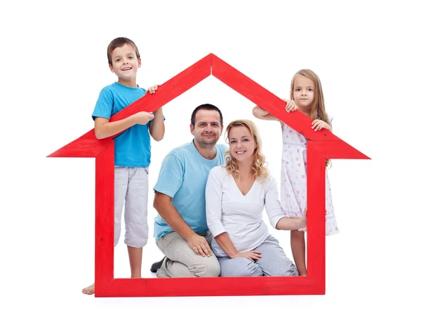 Молодая семья с двумя детьми за вывеской дома — стоковое фото