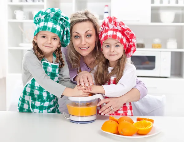 女性と子供たちは新鮮なフルーツ ジュースを作る — ストック写真