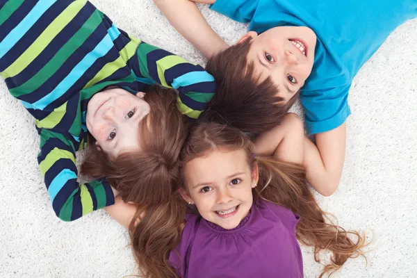 Kids laying on the floor together Royalty Free Stock Images