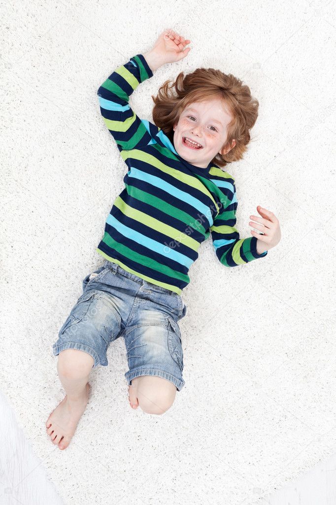 Happy little boy having fun on the floor