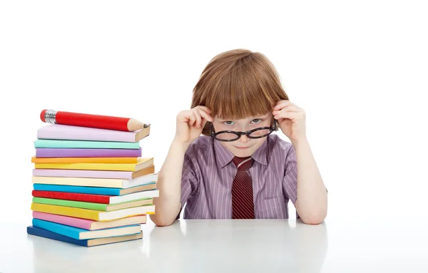 Маленький мальчик в очках и много книг — стоковое фото