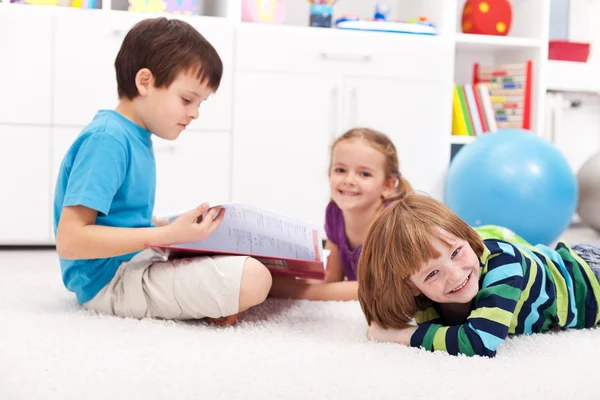Дети читают книгу и веселятся — стоковое фото