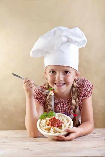 Piccolo chef che mangia pasta con sugo di pomodoro e basilico — Foto Stock