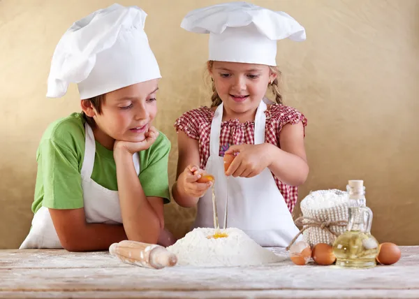 Kinder bereiten Kuchen zu - angefangen mit Mehl und Eiern — Stockfoto