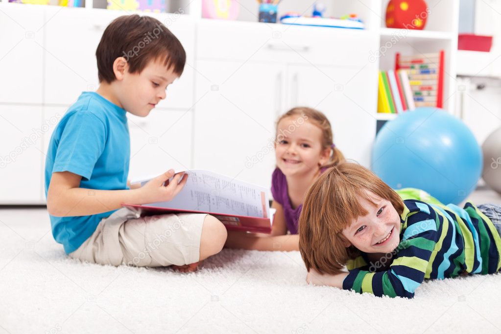 Kids reading a book and having fun