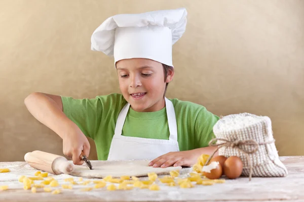 Little chef cutting the dough making pasta — Stock Photo, Image