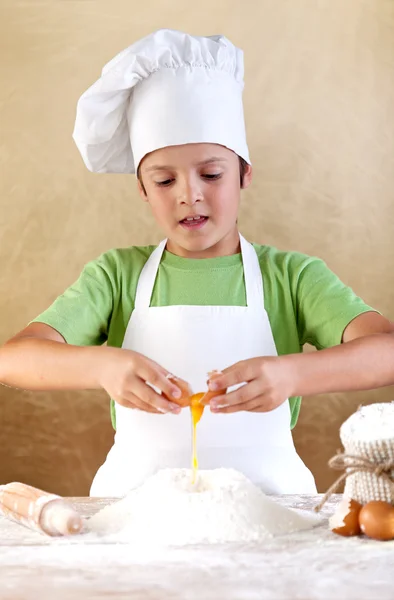 Niño con sombrero de chef preparando la masa — Foto de Stock