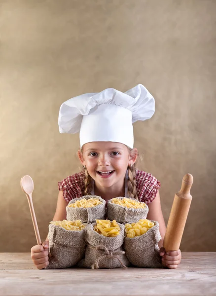 Gelukkig chef-kok kind met pasta assortiment en keukengerei — Stockfoto