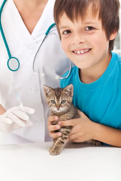 Menino recebendo seu gatinho para vacinação no veterinário — Fotografia de Stock