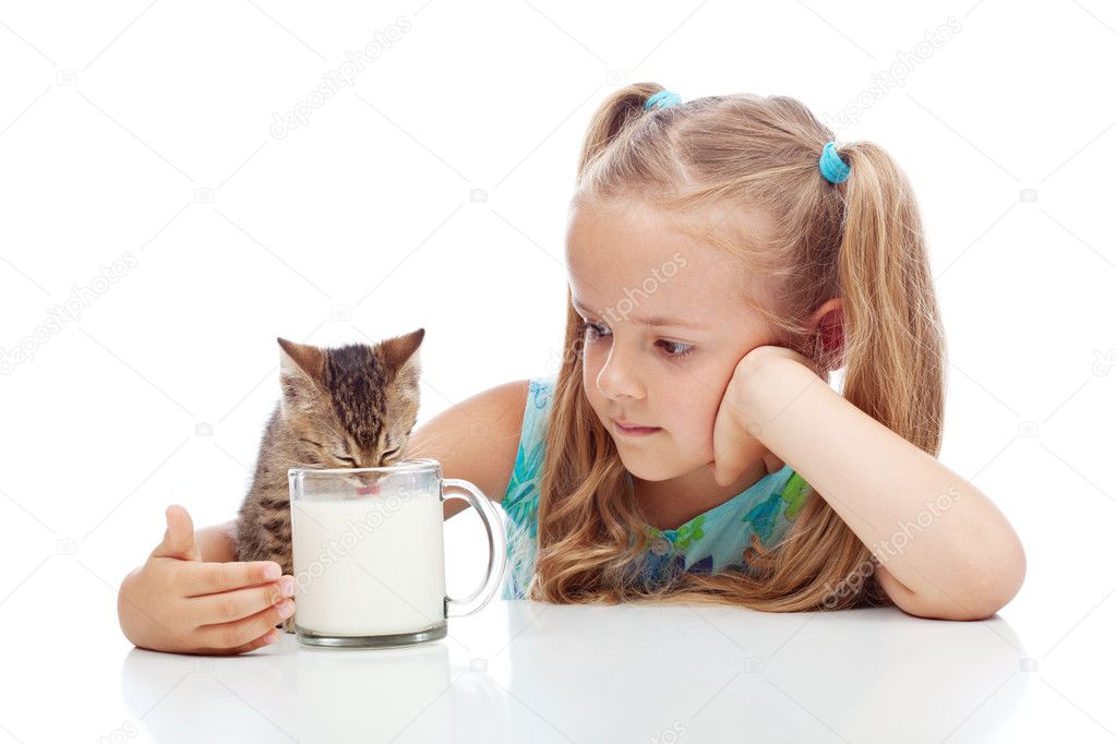 Little girl sharing milk with her kitten