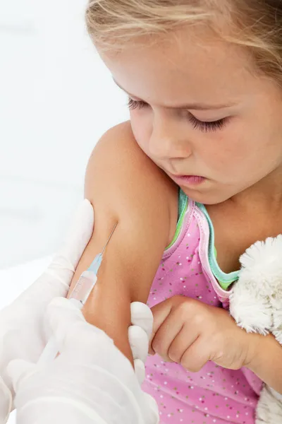 Беспокойная маленькая девочка получает инъекцию или вакцину — стоковое фото
