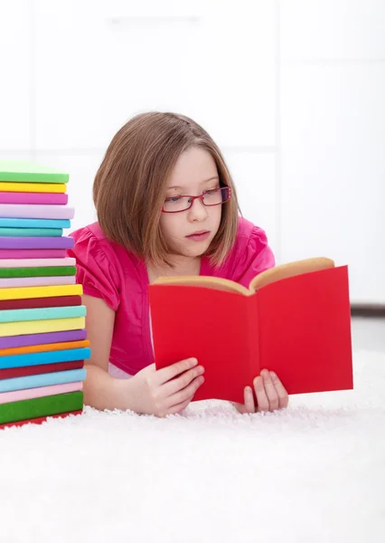 Mladá dívka pohlcená čtení — Stock fotografie