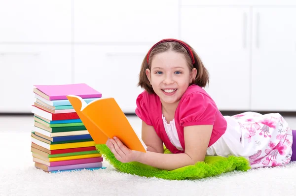 Glückliches junges Mädchen liest — Stockfoto